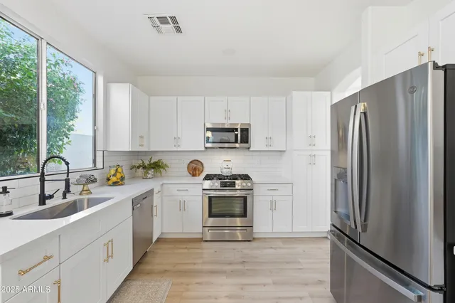 a kitchen with sink a refrigerator and cabinets