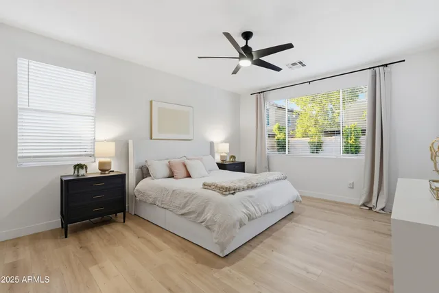 a bedroom with a bed a lamp and a ceiling fan
