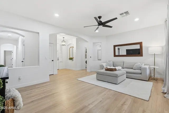 a living room with furniture kitchen view and a chandelier