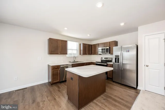 a kitchen with stainless steel appliances granite countertop a refrigerator a stove top oven a sink and dishwasher