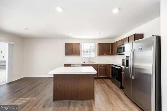 a kitchen with cabinets a sink and stainless steel appliances