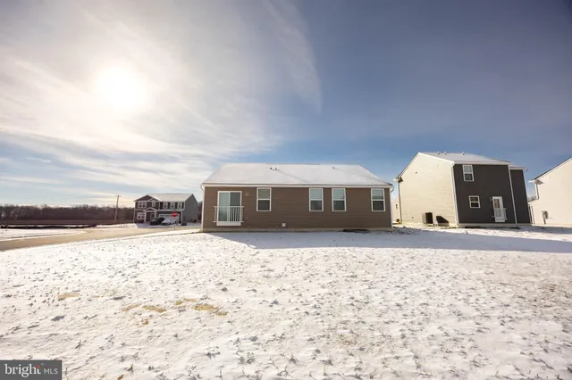 a view of a house with a snow in front of yard