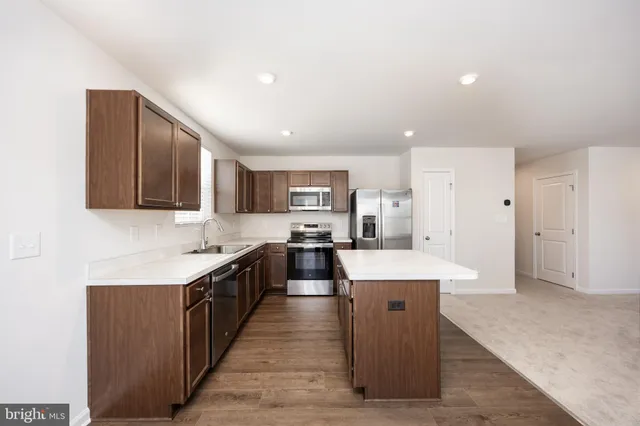 a large kitchen with stainless steel appliances lots of counter space and wooden floor