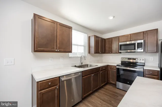 a kitchen with stainless steel appliances granite countertop a sink stove and microwave