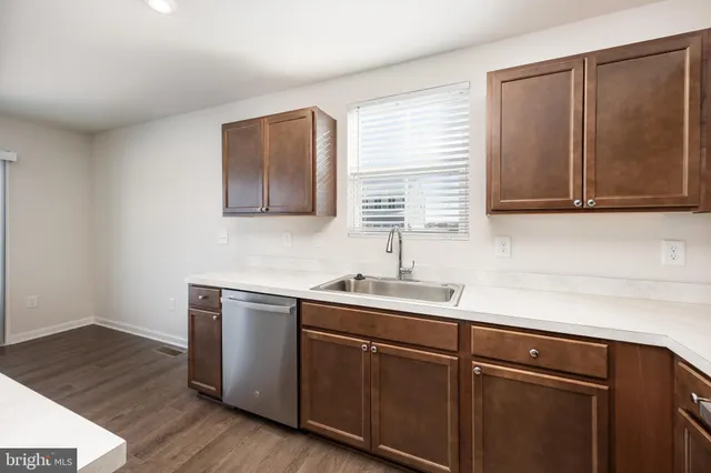 a kitchen with a sink cabinets and wooden floor