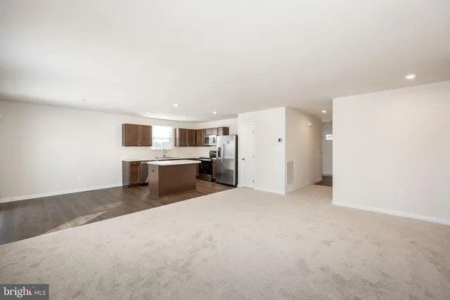 a large white kitchen with a refrigerator and a stove top oven