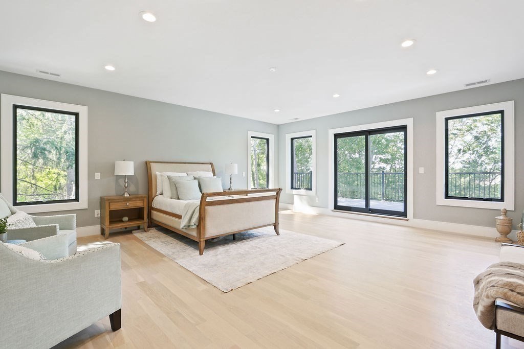 216 Greendale Avenue Needham, MA 02494 - Photo 19 of 40 a spacious bedroom with a bed and a couch with window