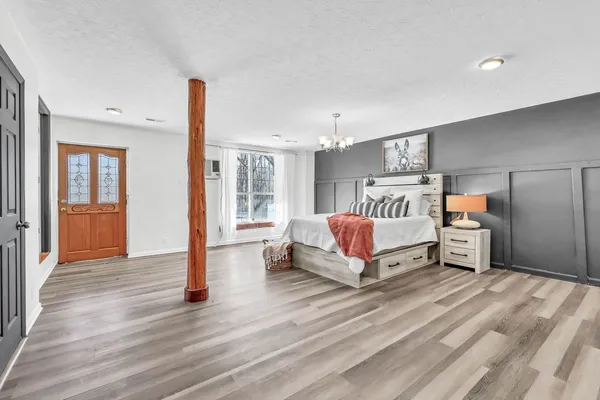a bedroom with a bed and wooden floor