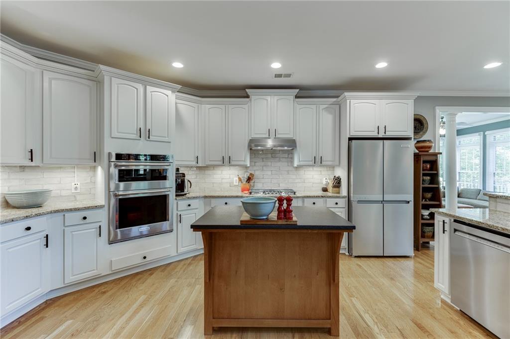 2758 Pathview Drive Dacula, GA 30019 - Photo 11 of 48 a kitchen with kitchen island white cabinets and stainless steel appliances