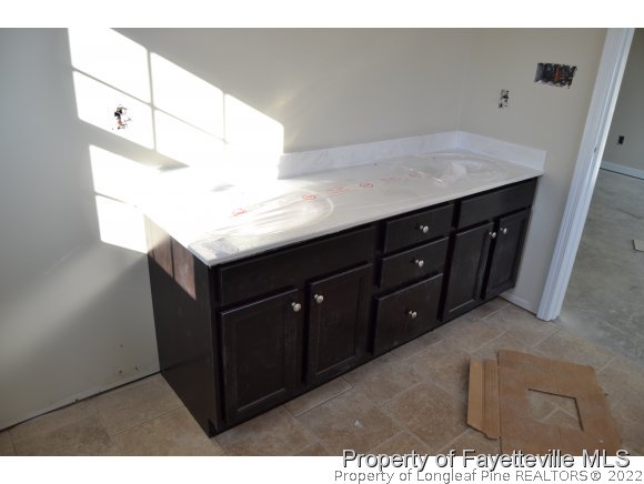9628 Lukes Run Road Linden, NC 28356 - Photo 18 of 25 a kitchen with a sink a mirror and wooden cabinets