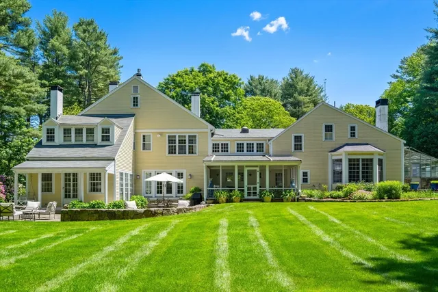 a front view of a house with a garden and trees