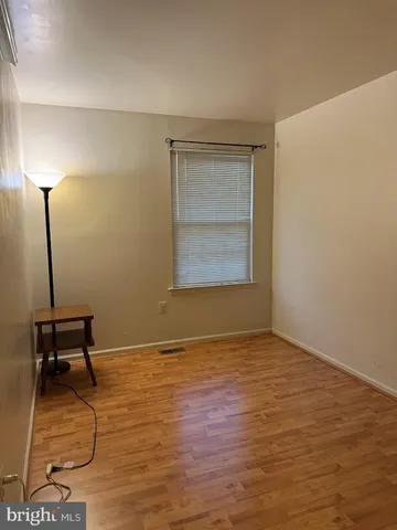 a view of a room with wooden floor and a window