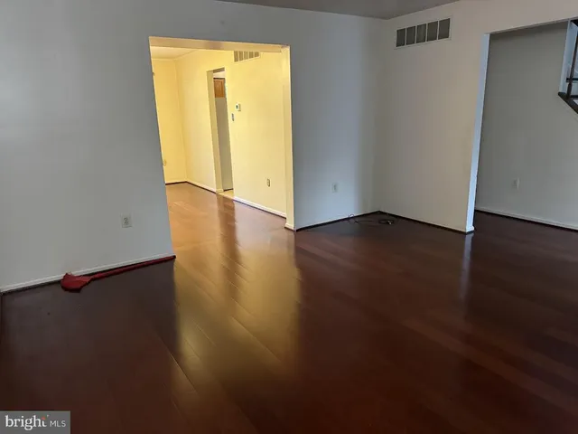 an empty room with wooden floor and closet