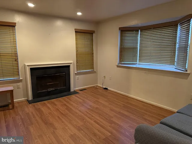 a view of empty room with wooden floor and fireplace