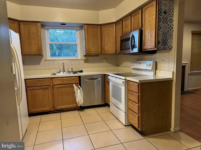 a kitchen with stainless steel appliances a sink a stove a microwave a counter top space and cabinets