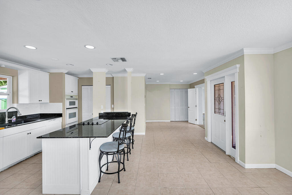 614 Southeast Flamingo Avenue Stuart, FL 34996 - Photo 13 of 49 a kitchen with stainless steel appliances kitchen island granite countertop a sink and cabinets