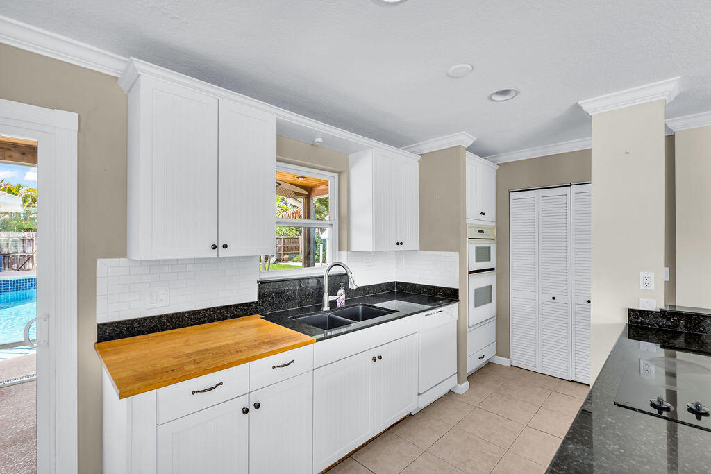 614 Southeast Flamingo Avenue Stuart, FL 34996 - Photo 16 of 49 a kitchen with stainless steel appliances a stove a refrigerator and cabinets