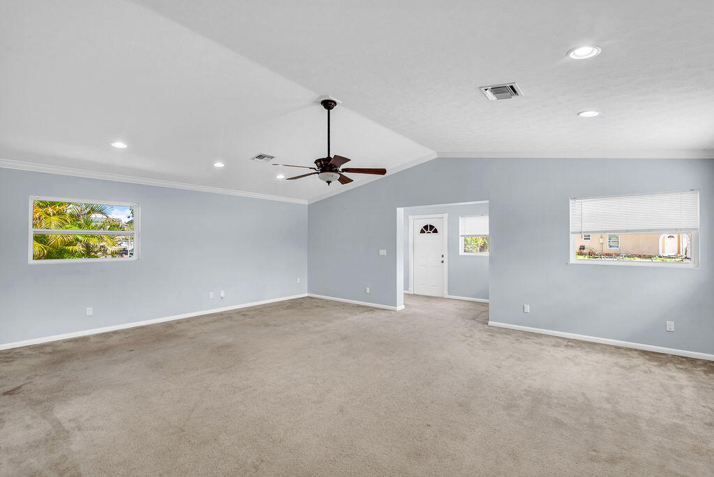 614 Southeast Flamingo Avenue Stuart, FL 34996 - Photo 23 of 49 an empty room with chandelier fan and windows