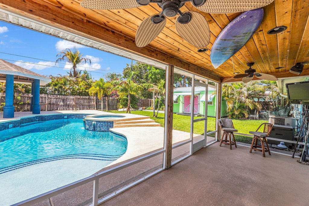 614 Southeast Flamingo Avenue Stuart, FL 34996 - Photo 39 of 49 a view of a swimming pool with a lounge chairs in front of a house