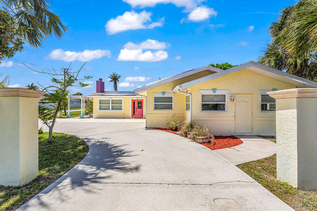 614 Southeast Flamingo Avenue Stuart, FL 34996 - Photo 7 of 49 a front view of a house with a yard