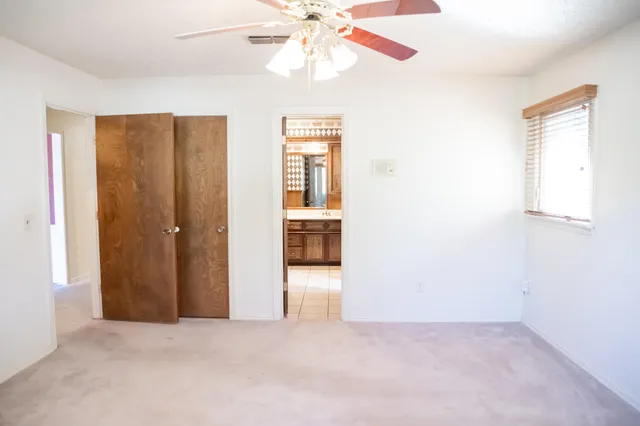 an empty room with fan and windows