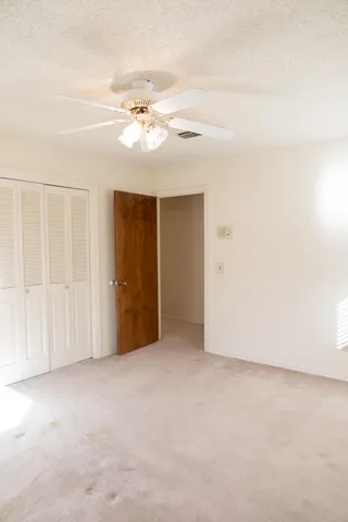 an empty room with chandelier fan