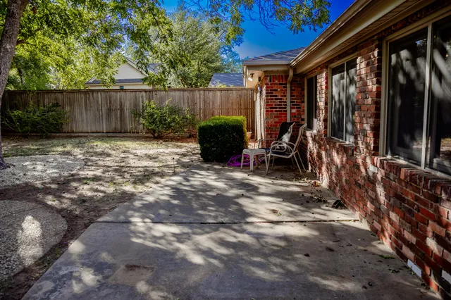 a view of a backyard with table and chairs and a large tree