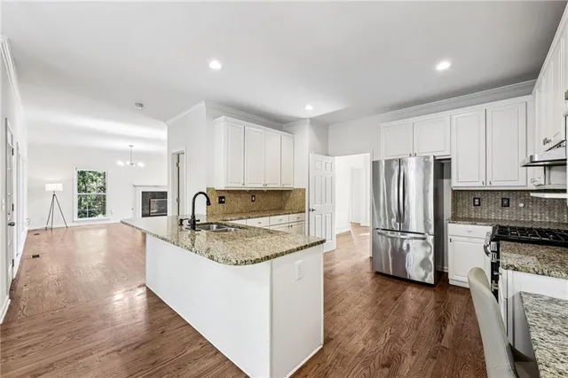 a kitchen with a refrigerator sink and cabinets