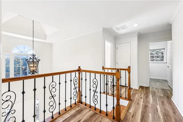 a view of a hallway with wooden floor and stairs