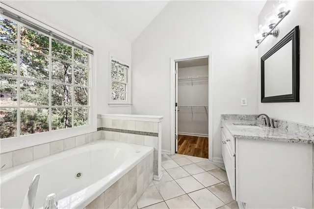 a bathroom with a tub sink and mirror