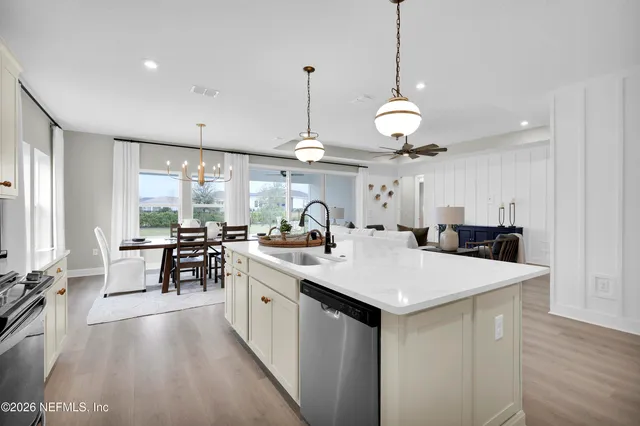 a kitchen with stainless steel appliances kitchen island a table chairs refrigerator and microwave