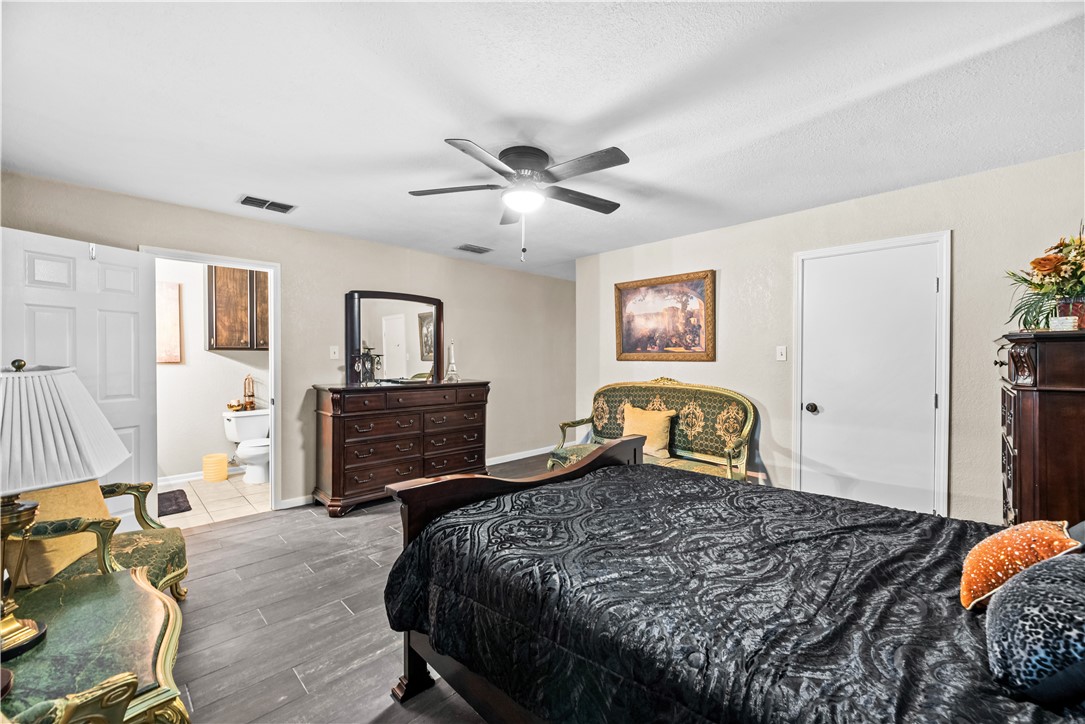 5213 Inverness Drive Corpus Christi, TX 78413 - Photo 11 of 23 a bedroom with a bed and wooden floor