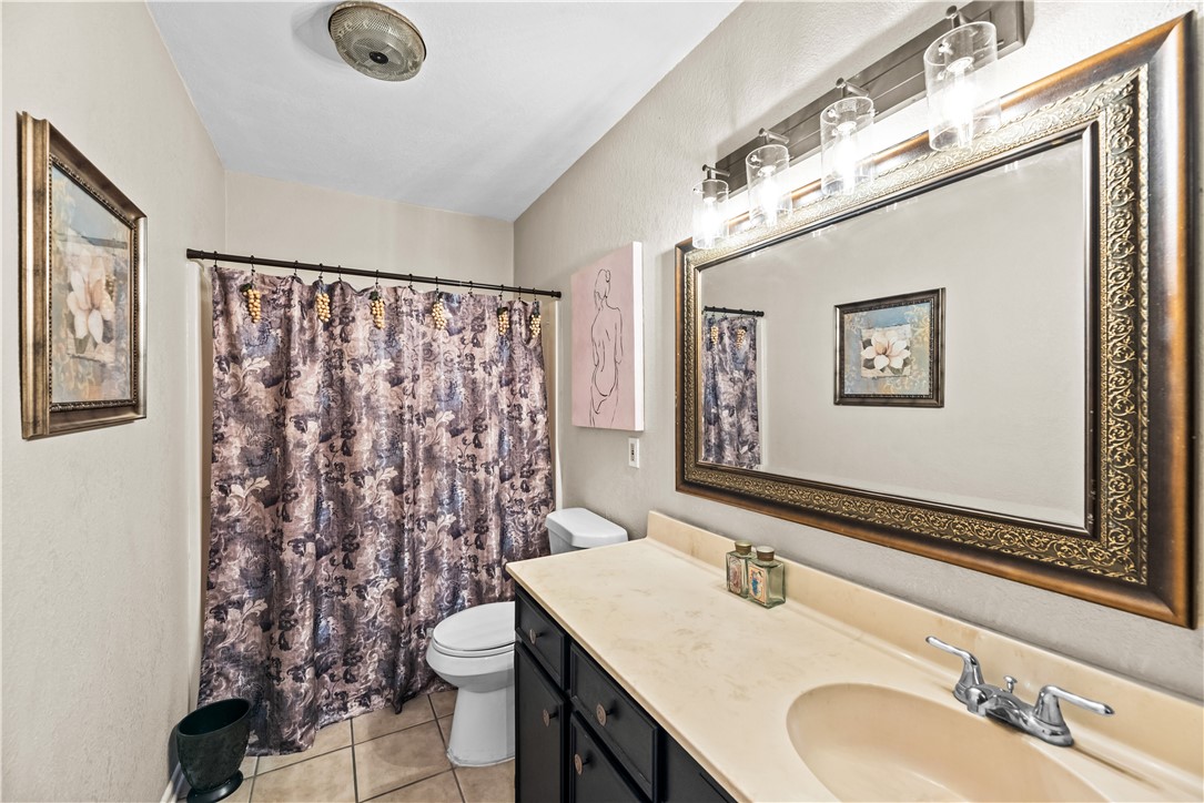 5213 Inverness Drive Corpus Christi, TX 78413 - Photo 20 of 23 a bathroom with a granite countertop sink mirror vanity and toilet