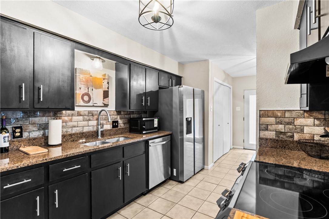 5213 Inverness Drive Corpus Christi, TX 78413 - Photo 8 of 23 a kitchen with stainless steel appliances granite countertop a refrigerator and a stove top oven