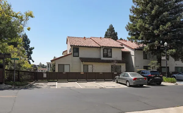 a front view of a house with a yard and parking
