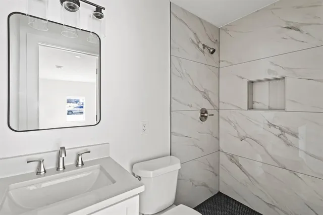 a bathroom with a toilet sink and shower