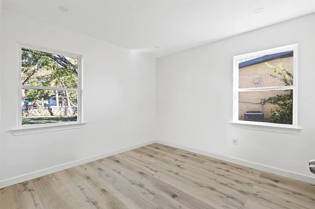an empty room with wooden floor and a window