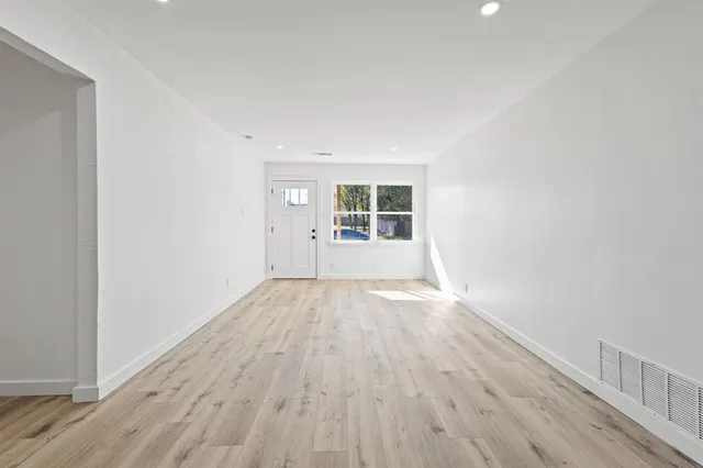 wooden floor in an empty room with a window
