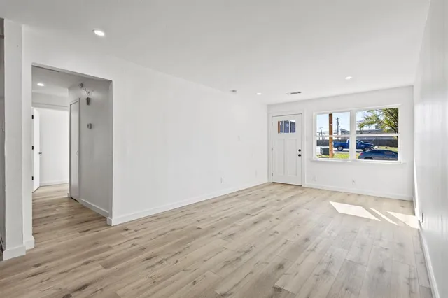 a view of a kitchen with wooden floor and natural light