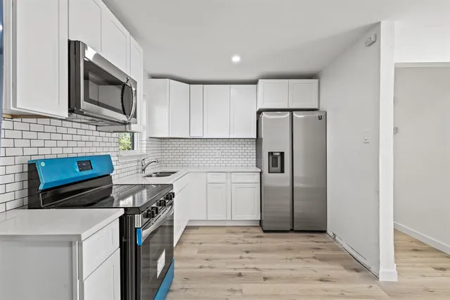 a kitchen with stainless steel appliances a refrigerator a stove a microwave and cabinets