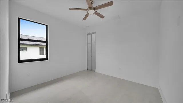an empty room with windows and fan