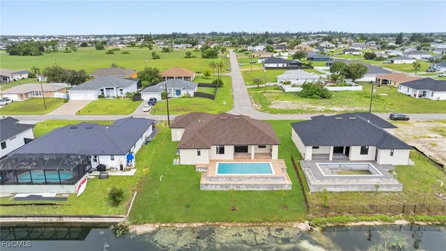 an aerial view of residential houses with outdoor space and swimming pool