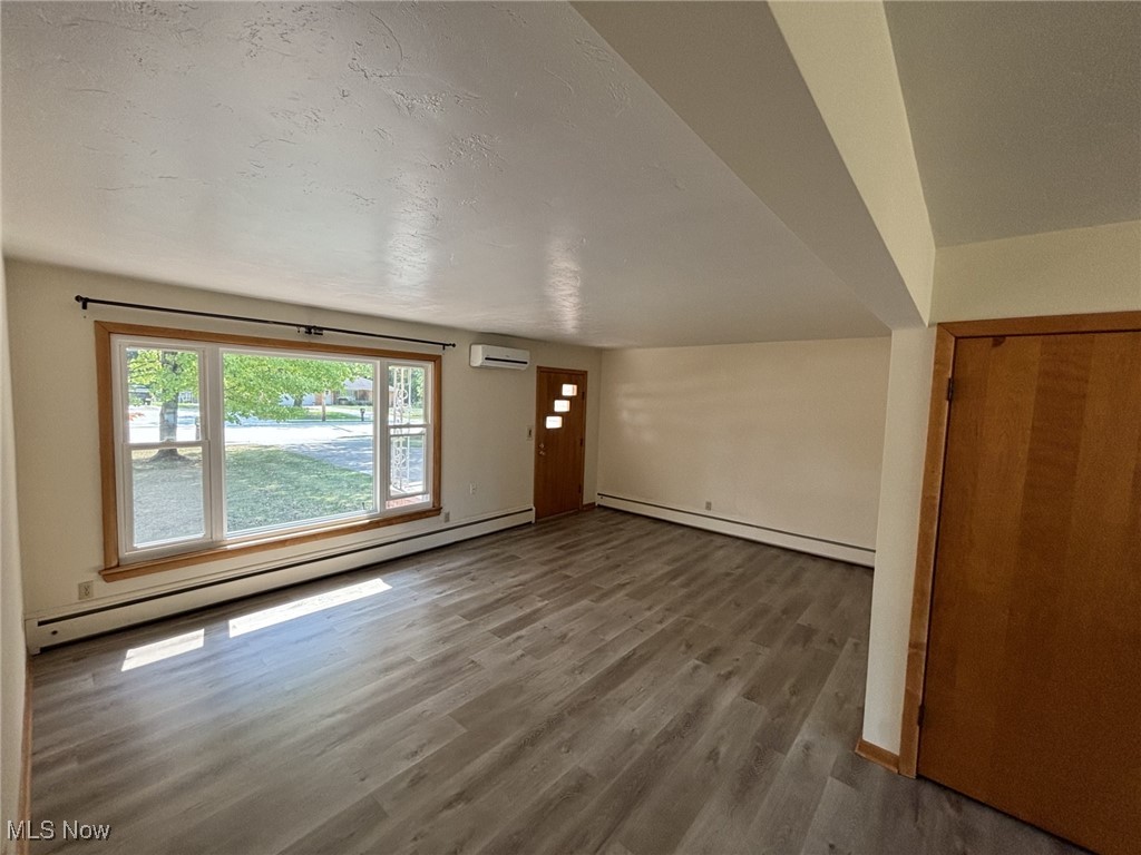 12060 West Sprague Road Parma, OH 44130 - Photo 16 of 30 The front/living room features an updated & large window providing an abundance of natural light. The wall-mounted air conditioner is not working. Note the luxury, vinyl-plank flooring.