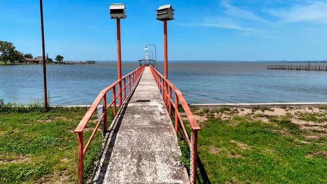 an aerial view of a house with a yard and lake view