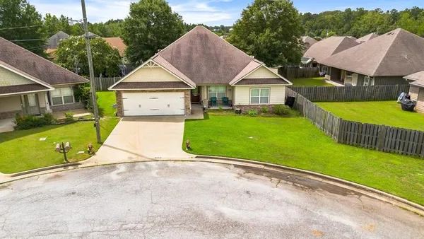 a view of house with garden and a car parked in front of it