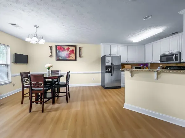 a view of kitchen with refrigerator microwave and wooden floor