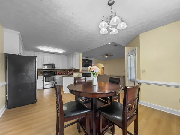 a view of a dining room with furniture and a chandelier