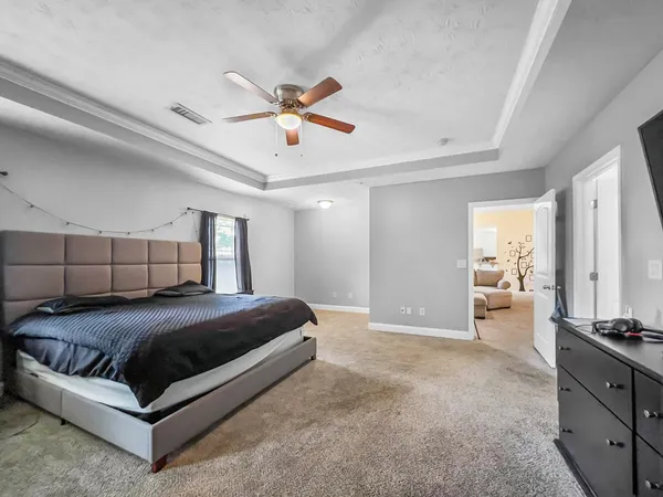 a bedroom with a large bed and ceiling fan