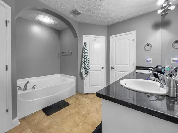 a spacious bathroom with a tub sink and mirror
