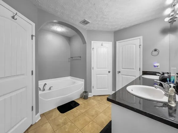 a bathroom with a tub sink and mirror